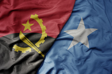 big waving national colorful flag of angola and national flag of somalia .