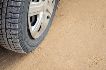 Fototapeta na wymiar Car with winter tires on snowy road, closeup view.