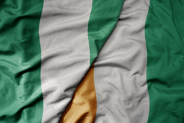 Obraz premium big waving national colorful flag of nigeria and national flag of cote divoire .