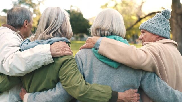 Elderly people, group and together with embrace in park, nature or woods on retirement with back view. Friends, man and woman with discussion for strong bond, love and trust in relationship with care