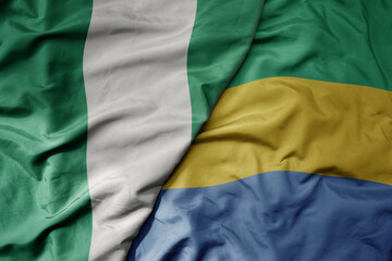 big waving national colorful flag of nigeria and national flag of gabon .