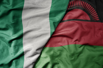 big waving national colorful flag of nigeria and national flag of malawi .