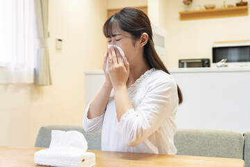 ティッシュで鼻を拭く女性