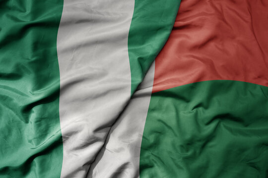 big waving national colorful flag of nigeria and national flag of madagascar .