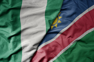 big waving national colorful flag of nigeria and national flag of namibia .