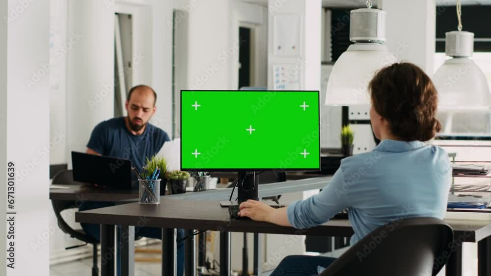 Poster employee using computer at desk, monitor running greenscreen template in business agency office. com