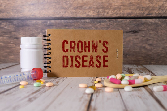 Paper with CROHN'S DISEASE on the office desk, stethoscope and pills, top view