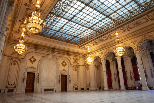 BUCHAREST, ROMANIA - MARCH 13, 2023: Selective blur on doors & opulent design with crystal chandeliers of hall in interior of Romanian palace of parliament in Bucharest, a symbol of romanian communism