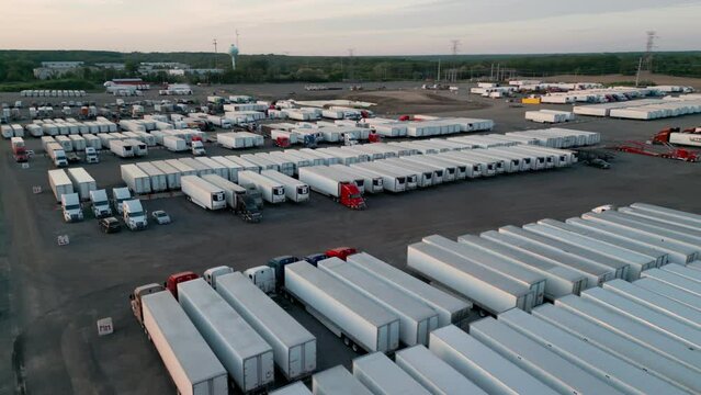 Trailer semi truck driver exiting truck stop parking lot. wide aerial footage
