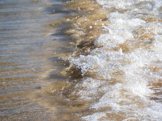 Fototapeta na wymiar 砂浜に打ち寄せる穏やかな波。 