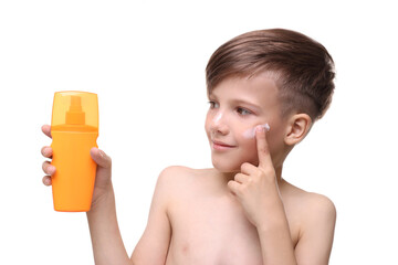 Smiling boy applying sun protection cream on white background