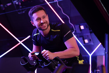 Man training on exercise bike in fitness club
