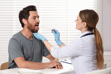 Doctor taking throat swab sample from man`s oral cavity indoors - obrazy, fototapety, plakaty