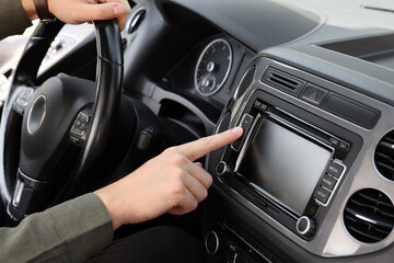 Choosing favorite radio. Man pressing button on vehicle audio in car, closeup - obrazy, fototapety, plakaty