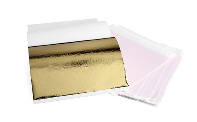 Many edible gold leaf sheets on white wooden table, closeup