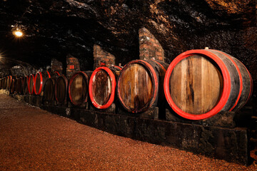 Many wooden barrels with alcohol drinks in cellar