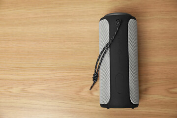 One portable bluetooth speaker on wooden table, top view with space for text. Audio equipment