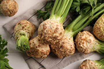 Fresh raw celery roots on white wooden table, above view