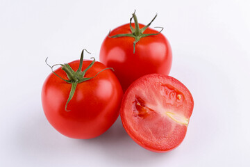 Whole and ripe red tomatoes on white background