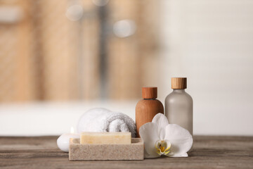 Composition with spa products, beautiful flower and candle on wooden table against blurred...