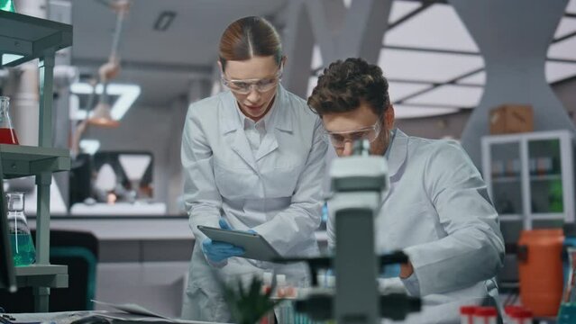Lab workers experimenting samples looking at computer data in clinic close up
