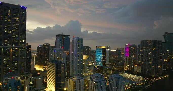 View from above of concrete and glass skyscraper buildings at night in downtown district of Miami Brickell in Florida, USA. Waterfront American megapolis with business financial district