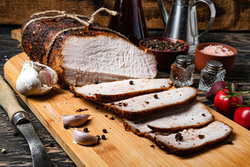 Boiled pork, baked in the oven meat with spices. Sliced pieces of meat on on cutting board.
