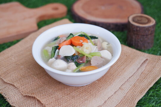 Capcay, stir fried vegetables with mushroom, meatballs and chicken. Served in white bowl