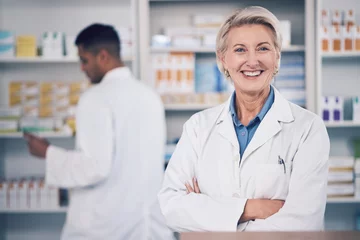 Tuinposter Woman, portrait and pharmacist smile with arms crossed for medical services, medicine advice and healthcare support. Mature female manager working with pride in retail drugstore, pharmacy and shop © Azeemud/peopleimages.com