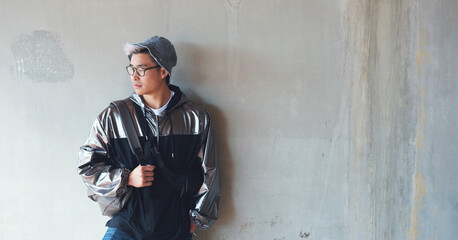 Fashion, student and gen z asian male streetwear, style and cool clothes on wall background,...