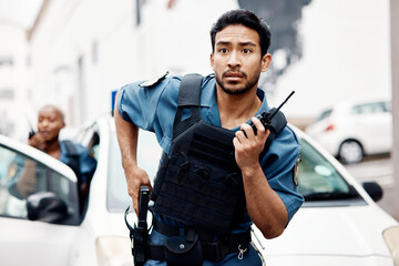 Asian man, police and walkie talkie with gun in city for suspect, communication or reinforcements. Serious male person, security guard or cop radio calling backup for crime in street of an urban town - obrazy, fototapety, plakaty