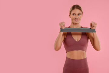 Woman exercising with elastic resistance band on pink background. Space for text