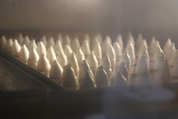 パティシエがデコレーション用にオーブンで焼いた大量のメレンゲ菓子、クリーム