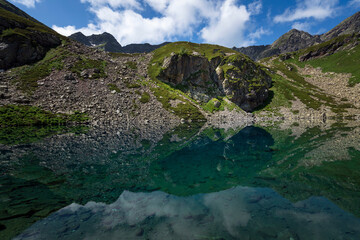 View of the Dukka lake "Rybka" on the Malaya Dukka River on the slopes of the Arkasar ridge in the North Caucasus on a sunny summer day, Arkhyz, Karachay-Cherkessia, Russia