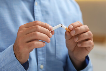 Stop smoking concept. Man breaking cigarette, closeup