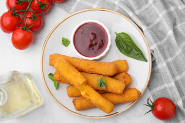 Tasty fried mozzarella sticks served with tomato sauce on white table, flat lay