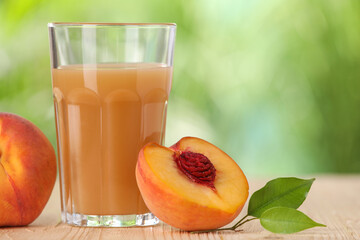 Tasty peach juice, fresh fruits and green leaves on wooden table outdoors, closeup