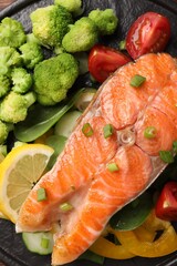 Healthy meal. Grilled salmon steak, green onion, lemon and vegetables on table, top view