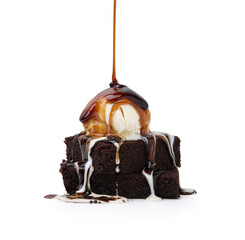 Pouring tasty caramel sauce onto ice cream and brownies isolated on white