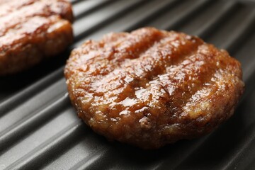 Delicious hamburger patties on electric grill, closeup