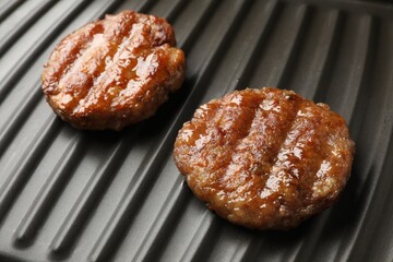 Delicious hamburger patties on electric grill, closeup
