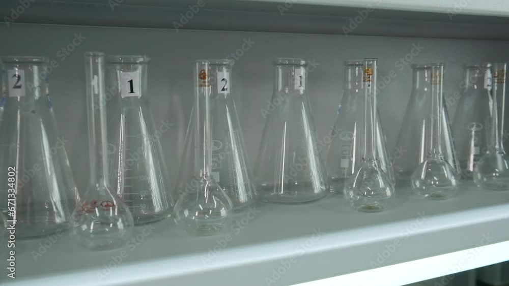 Aufkleber multiple laboratory flasks on the shelf ready to be used. clip. hand of a doctor or scientist in glo