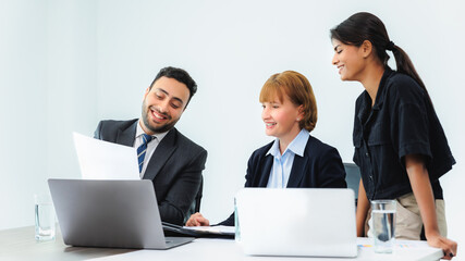 Obraz premium Three smiling diverse business colleagues having business strategy meeting.