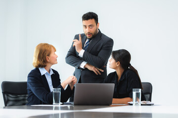 Fototapeta premium Group of three professional discussing numbers in a business meeting with use laptop. Team of business people brainstorming solutions for a project as they work towards the success of their company.
