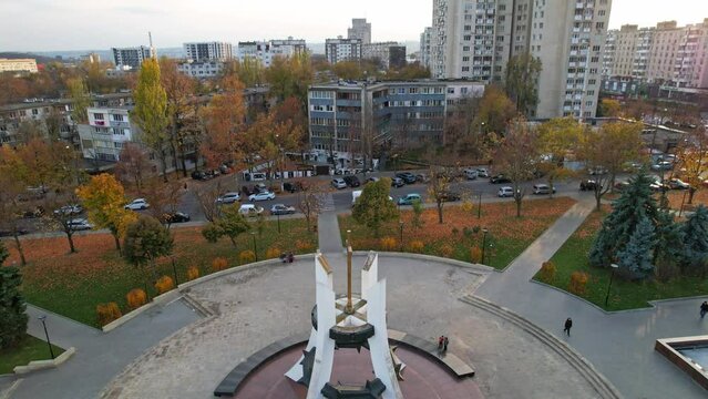 Panoramic aerial drone view of Afghan War Memorial To Sons of Motherland - Eternal Memory at autumn season. Multiple residential buildings, cars riding on background. Chisinau, Moldova. 4K video.