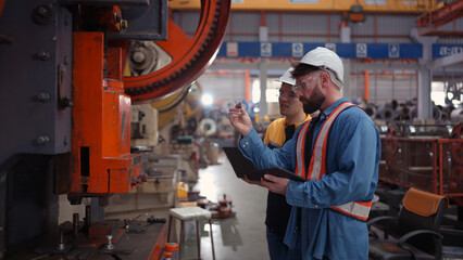 Engineer and technician discussing machinery in factory to plan inspection maintenance according to usage cycle, Concepts inspections based on usage cycle maintenance