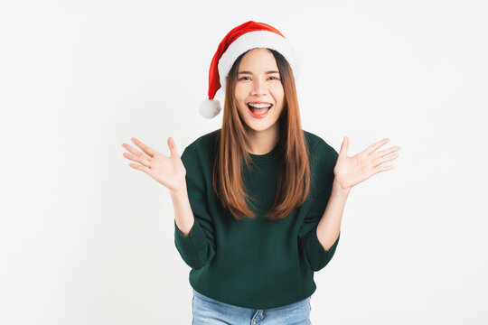 Cheerful beautiful Asian woman wearing red Christmas hat on white background.