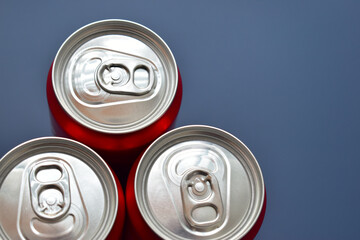 close up group of aluminium red cans soft drink put on blue texture background