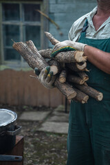 A man carries an armful of firewood.
