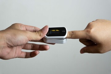 Close up of human finger while using Pulse Oximetry isolated on white background.